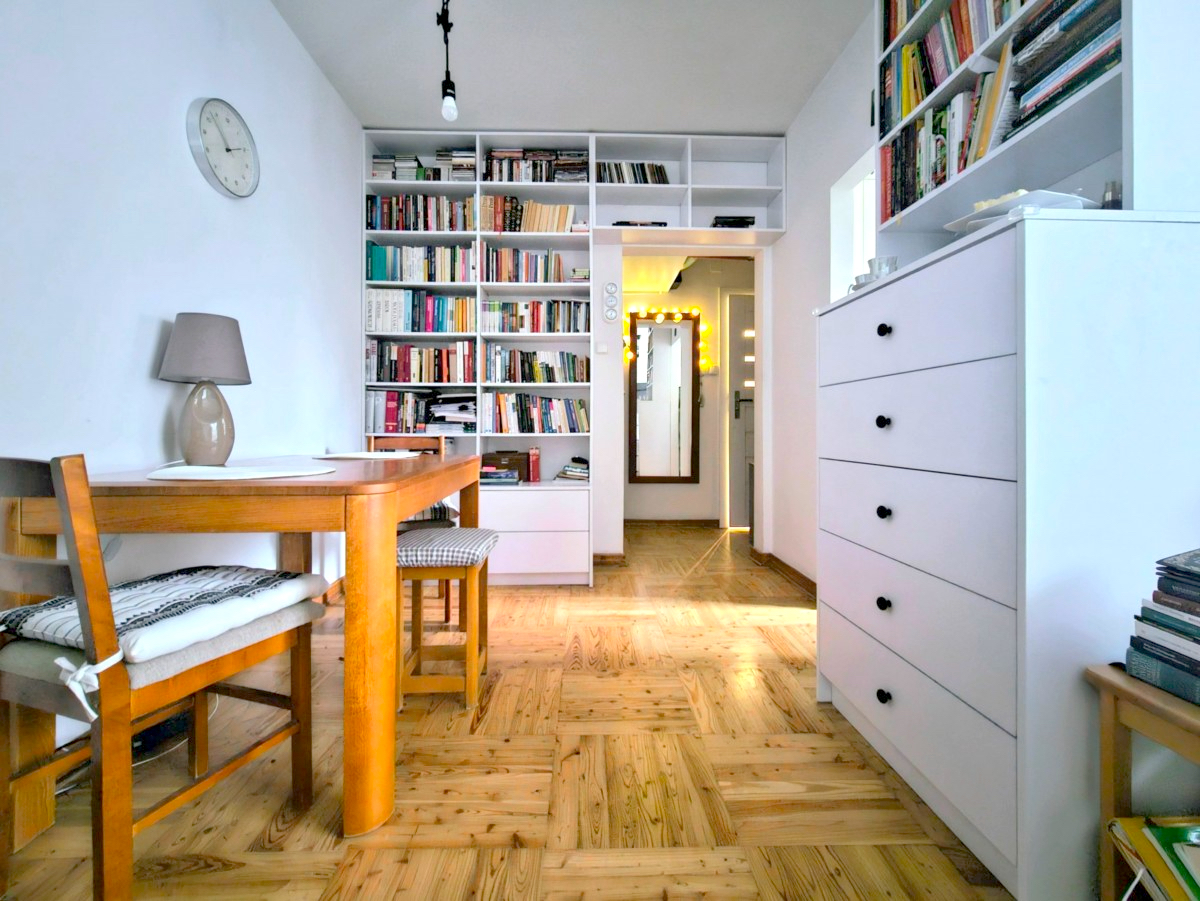 A photo of a white interior with books and table