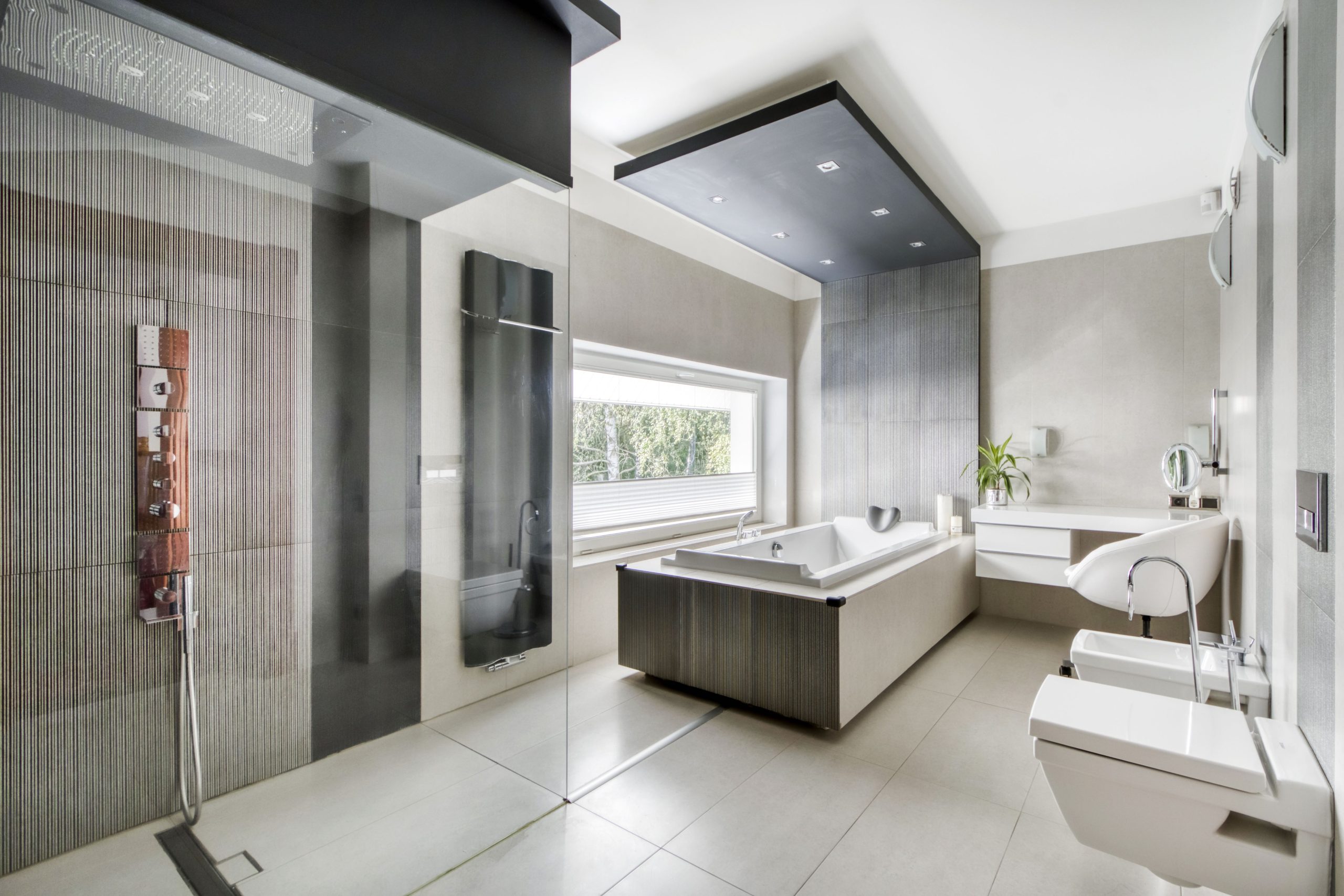 Interior photo of a luxury bathroom with spa size bathtub, shower, vanity, and makeup prep station